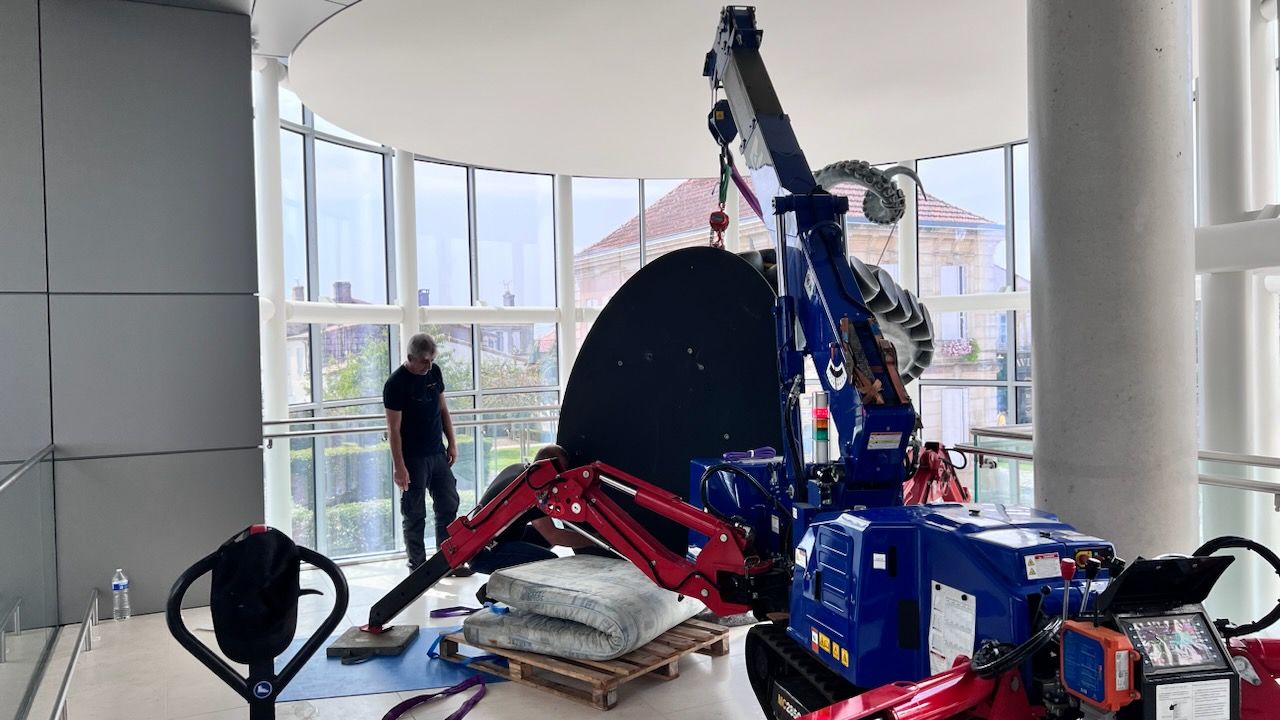 Mini-grue aidant à soulever une statue à l'intérieur d'un bâtiment