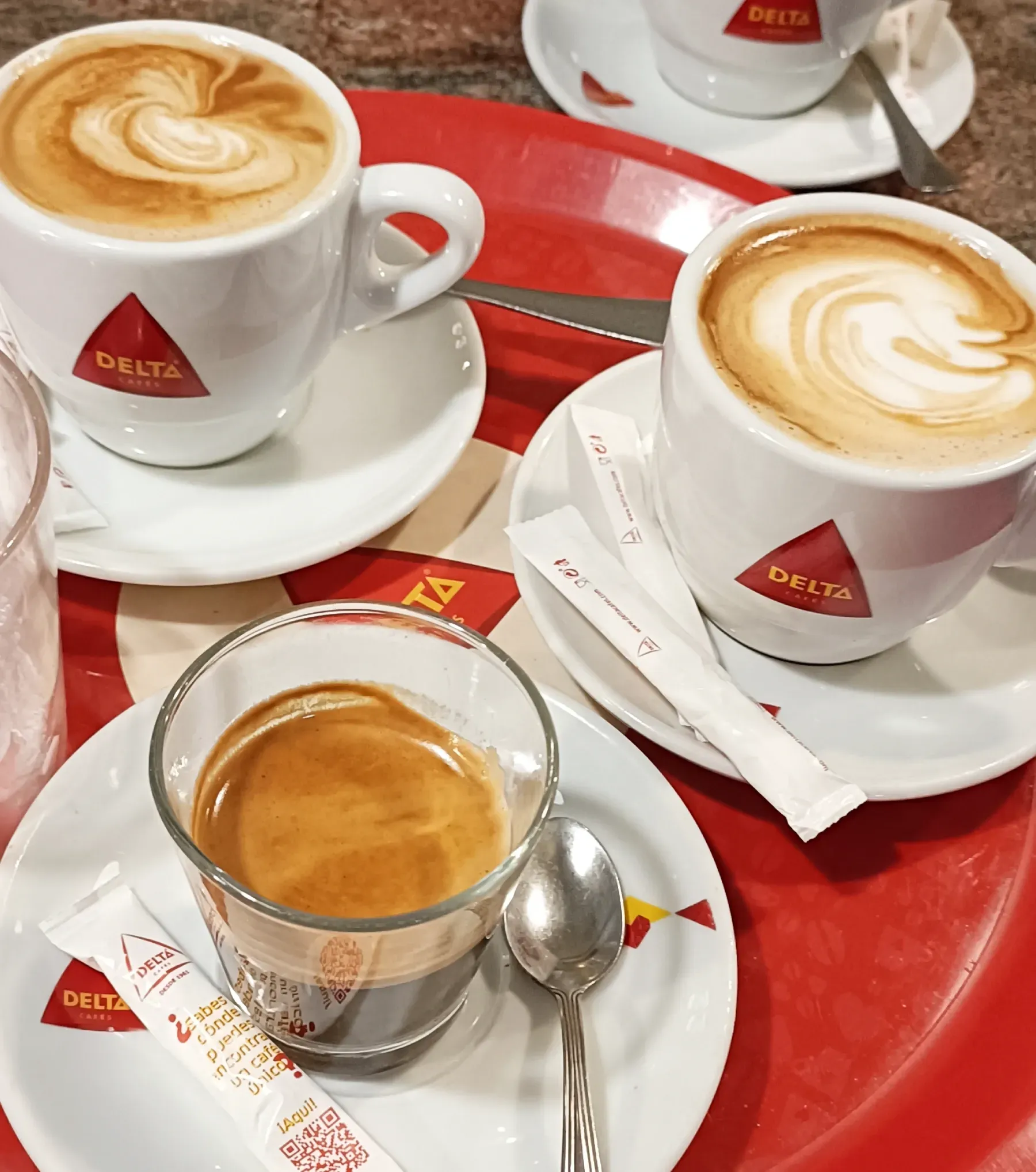 Barista vertiendo leche en una taza de café, creando arte latte.