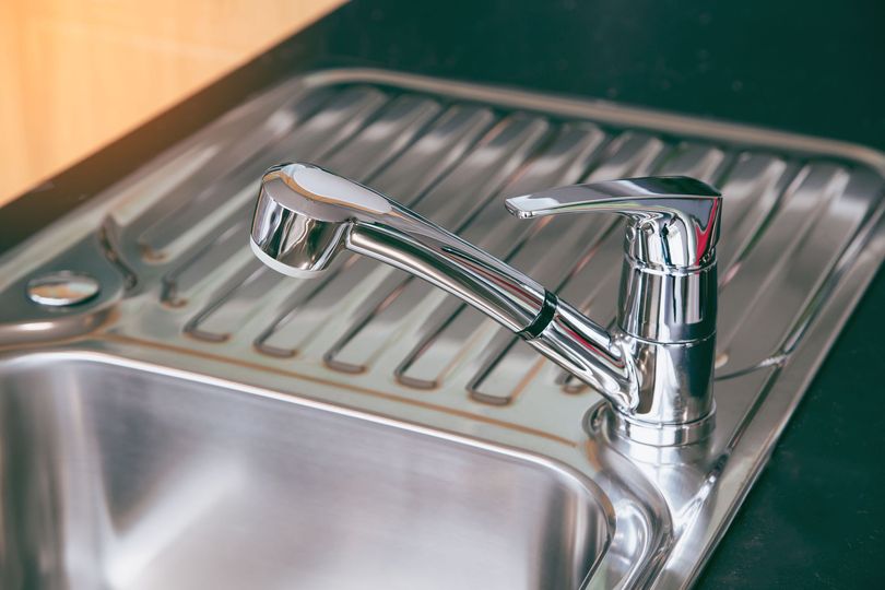 Fregadero de cocina cromado brillante con grifo extraíble.