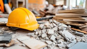 Casco amarillo sobre escombros en un sitio de construcción.