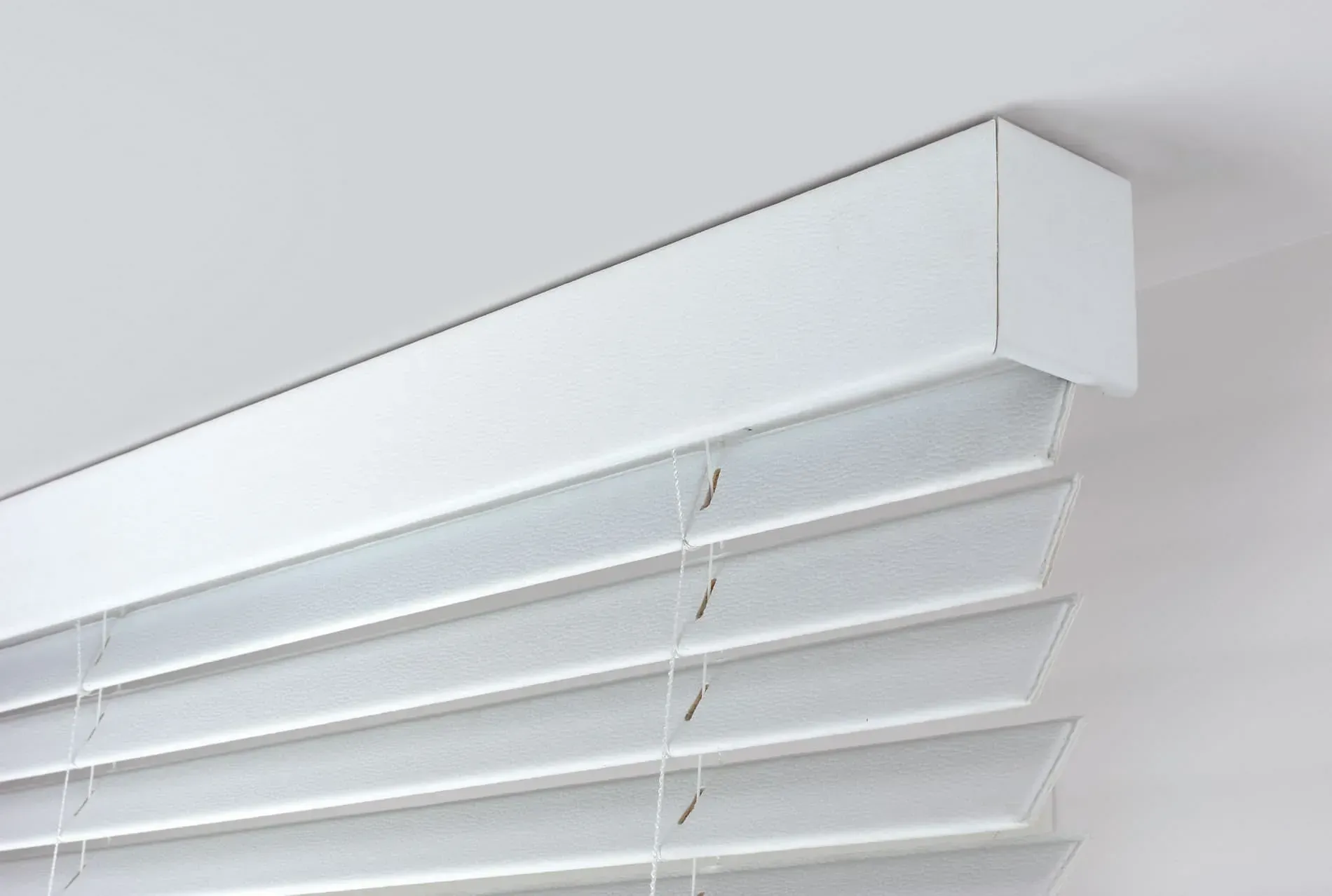 Un primer plano de una persiana blanca en una ventana.