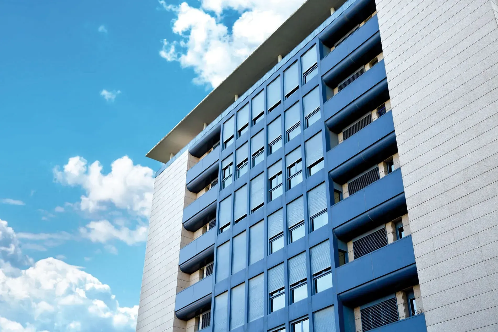 Un edificio azul y blanco con un cielo azul de fondo.