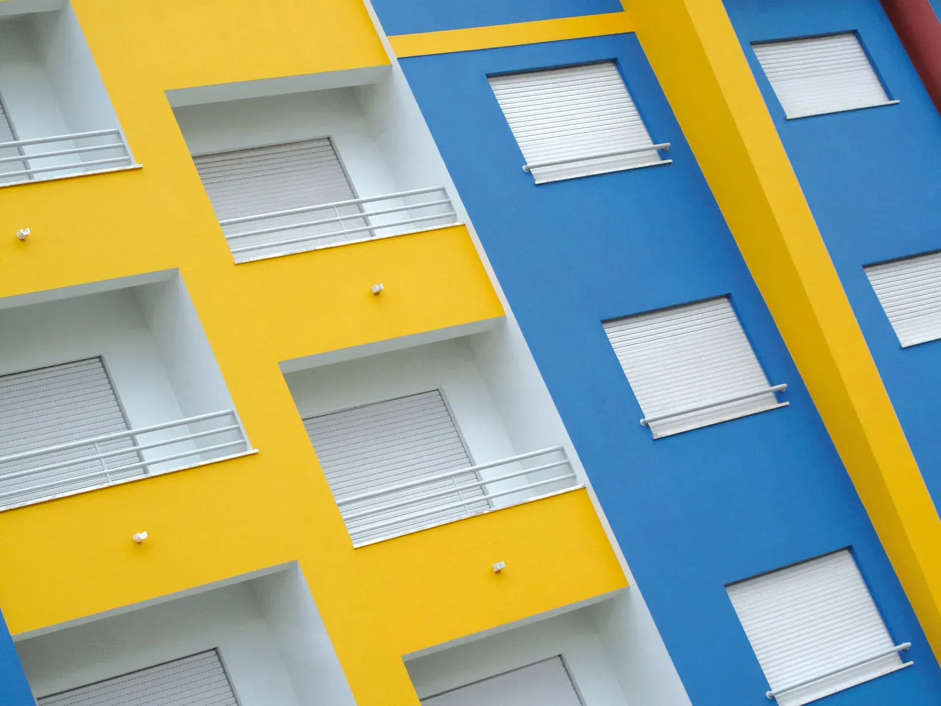 Un edificio azul y amarillo con balcones y ventanas.