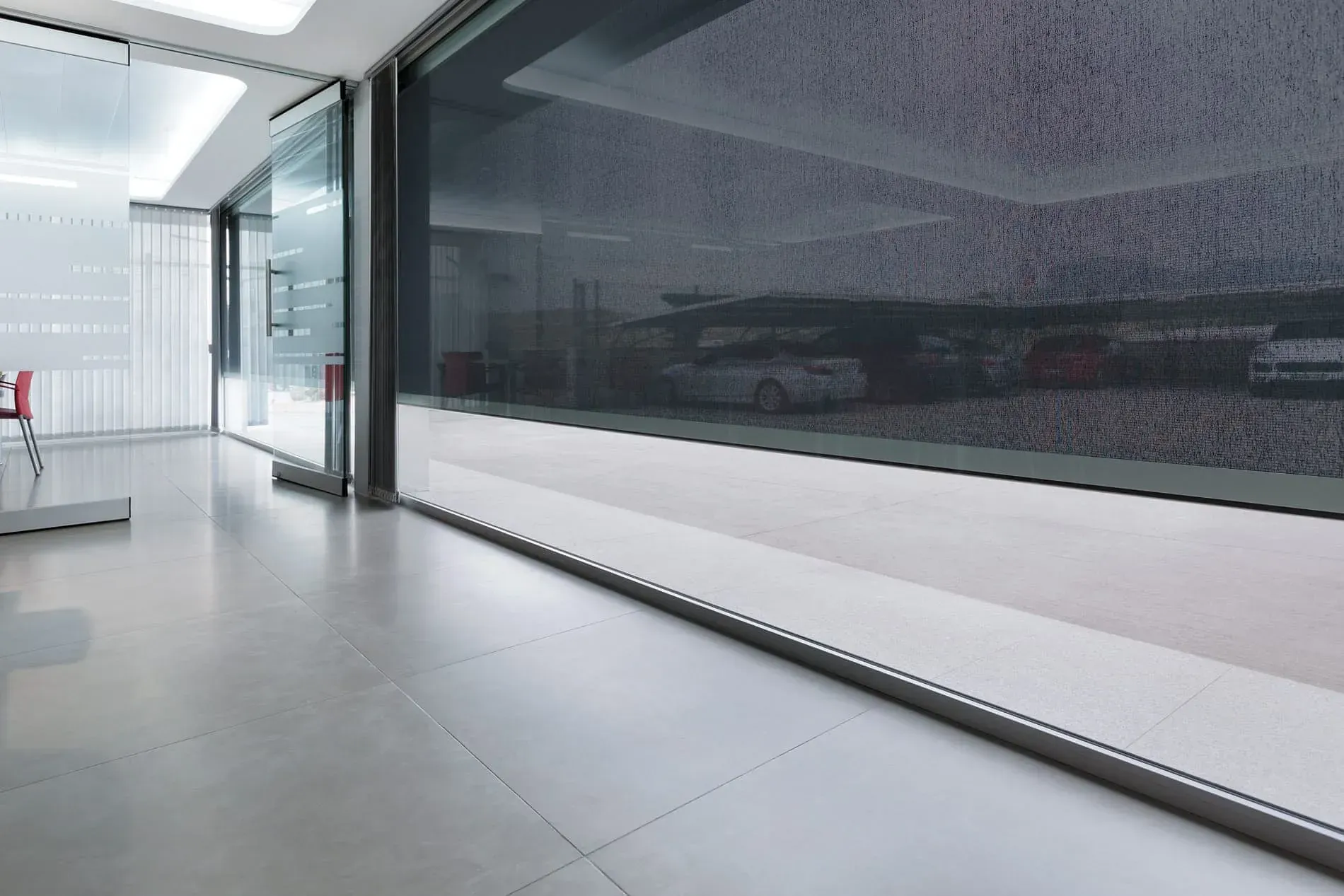 Una habitación con muchas ventanas y un reflejo de coches.