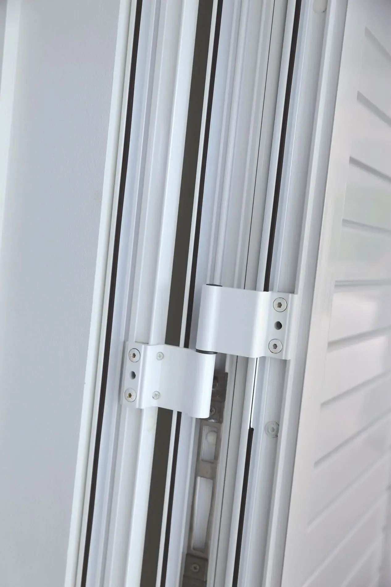 Un primer plano de una puerta blanca con una bisagra de metal.