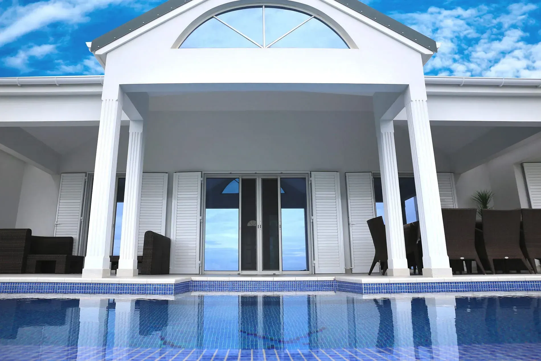 Una casa blanca con una piscina delante de ella