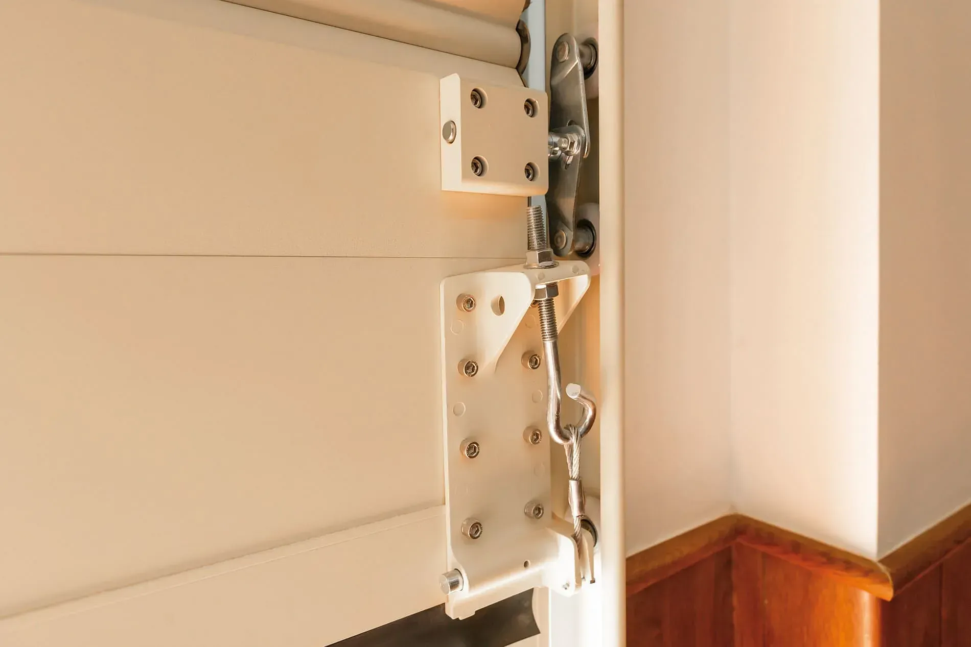 Un primer plano de una puerta blanca con un soporte de metal unido a ella.