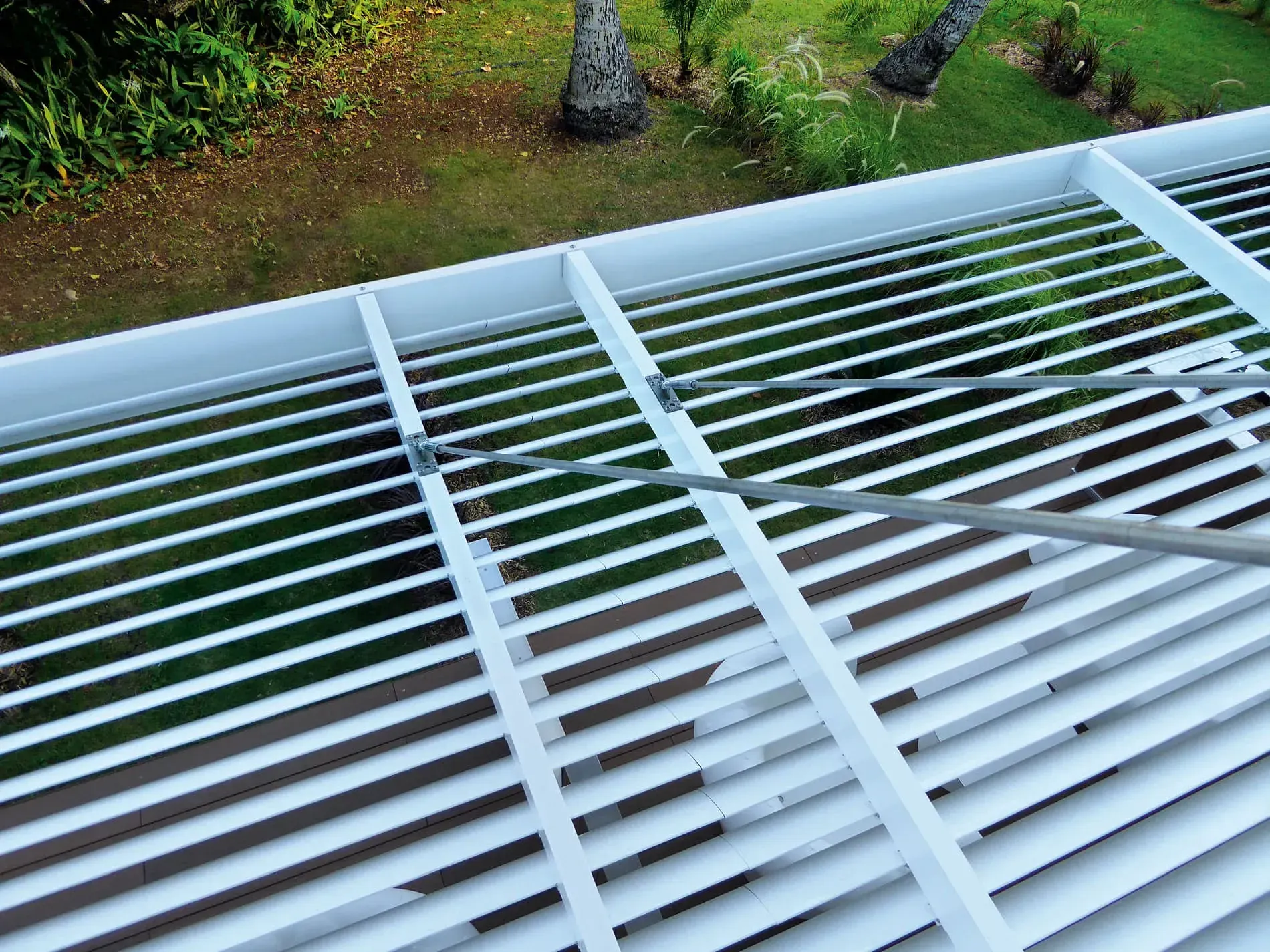 Un primer plano de una estructura de metal blanco con una valla al fondo.