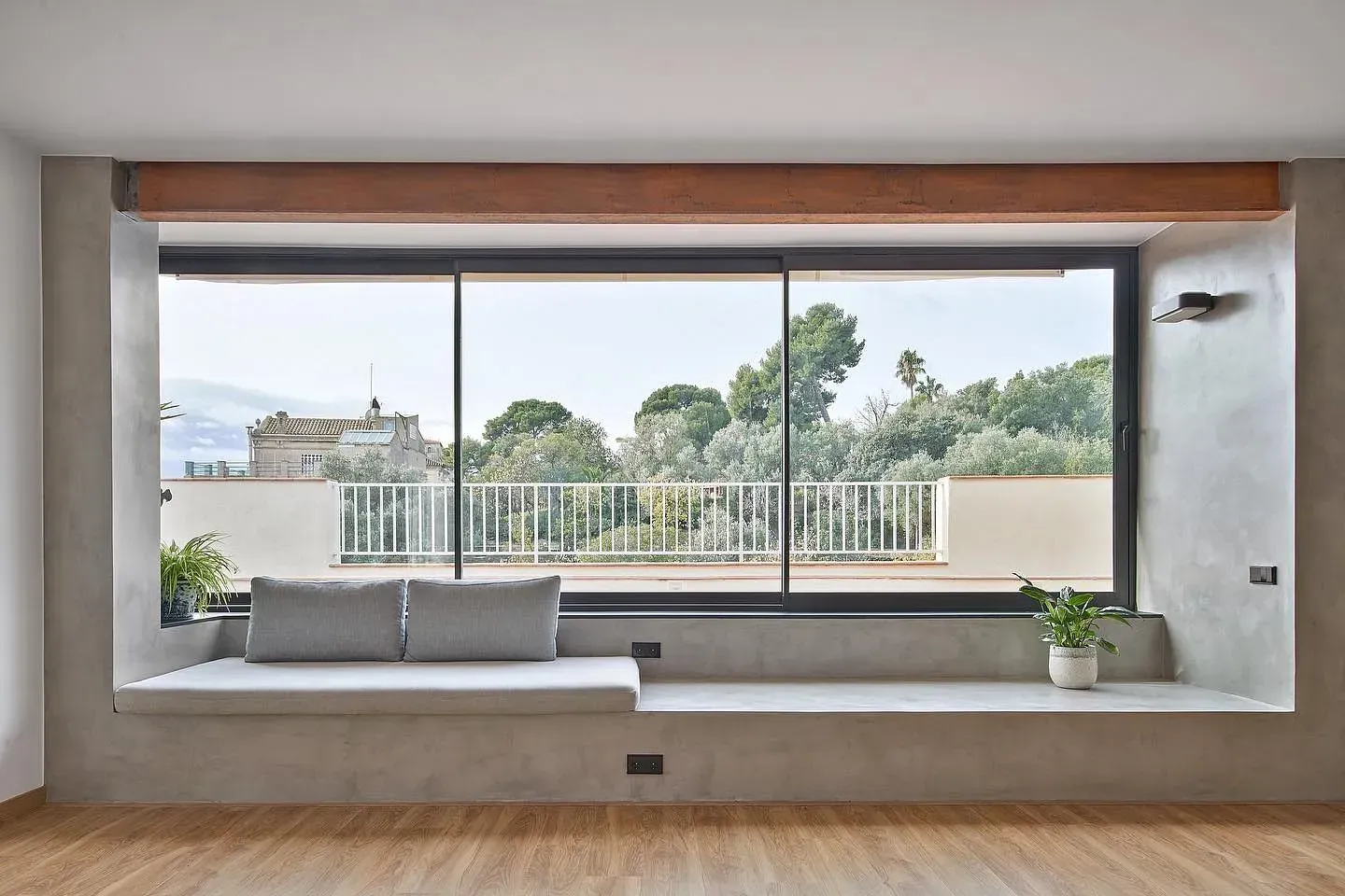 Una sala de estar con una gran ventana y un banco delante de ella.