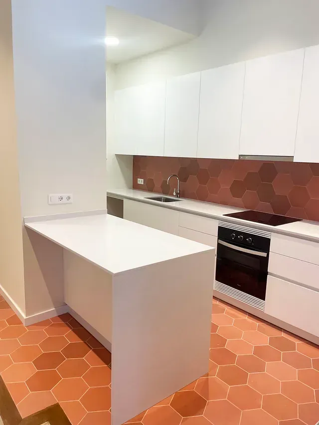 Hay una gran isla en el medio de la cocina.