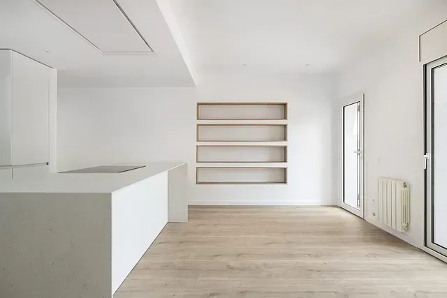 Una habitación vacía con paredes blancas y suelos de madera.