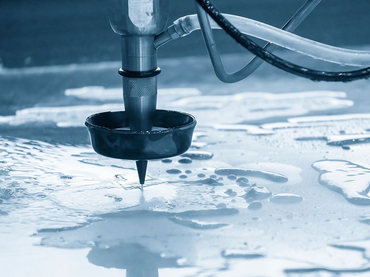 Machine de découpe au jet d'eau qui découpe une plaque en métal