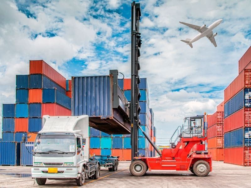 Una carretilla elevadora está cargando un contenedor en un camión en un almacén.