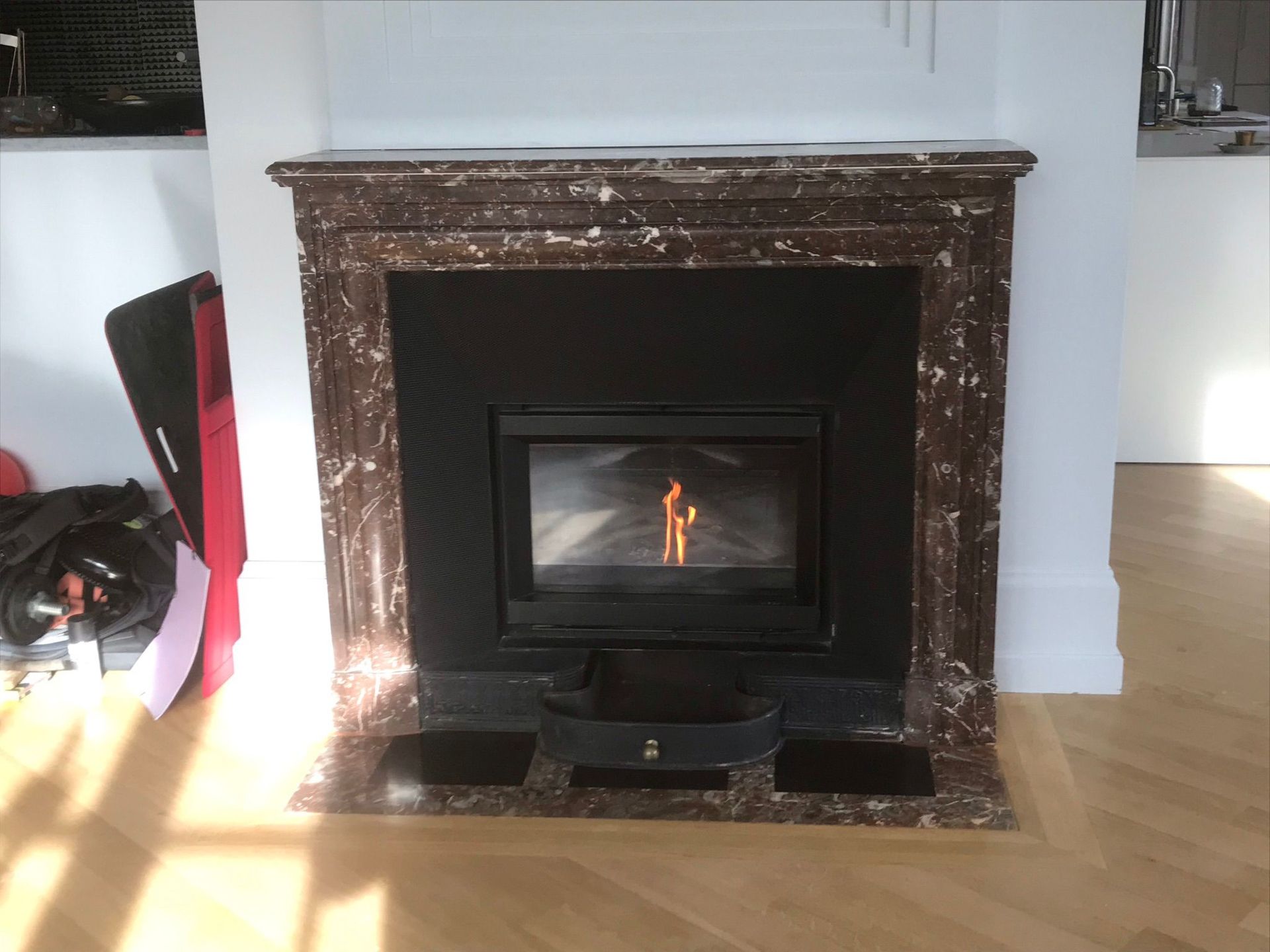 Cheminée en marbre avec un petit feu qui brûle dans un salon moderne.