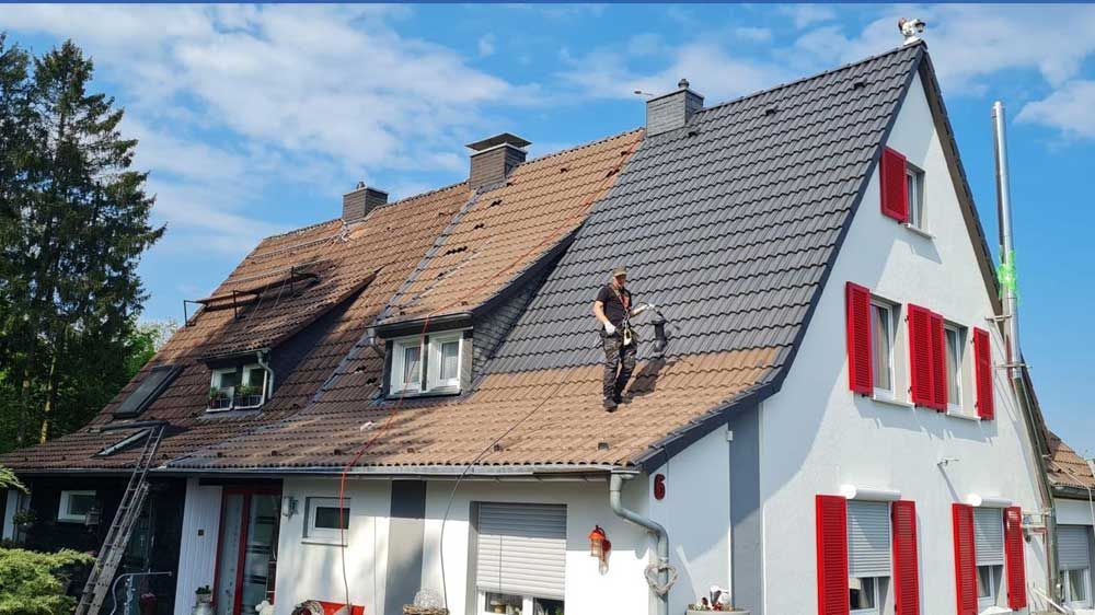 Ein Mann steht auf dem Dach eines Hauses