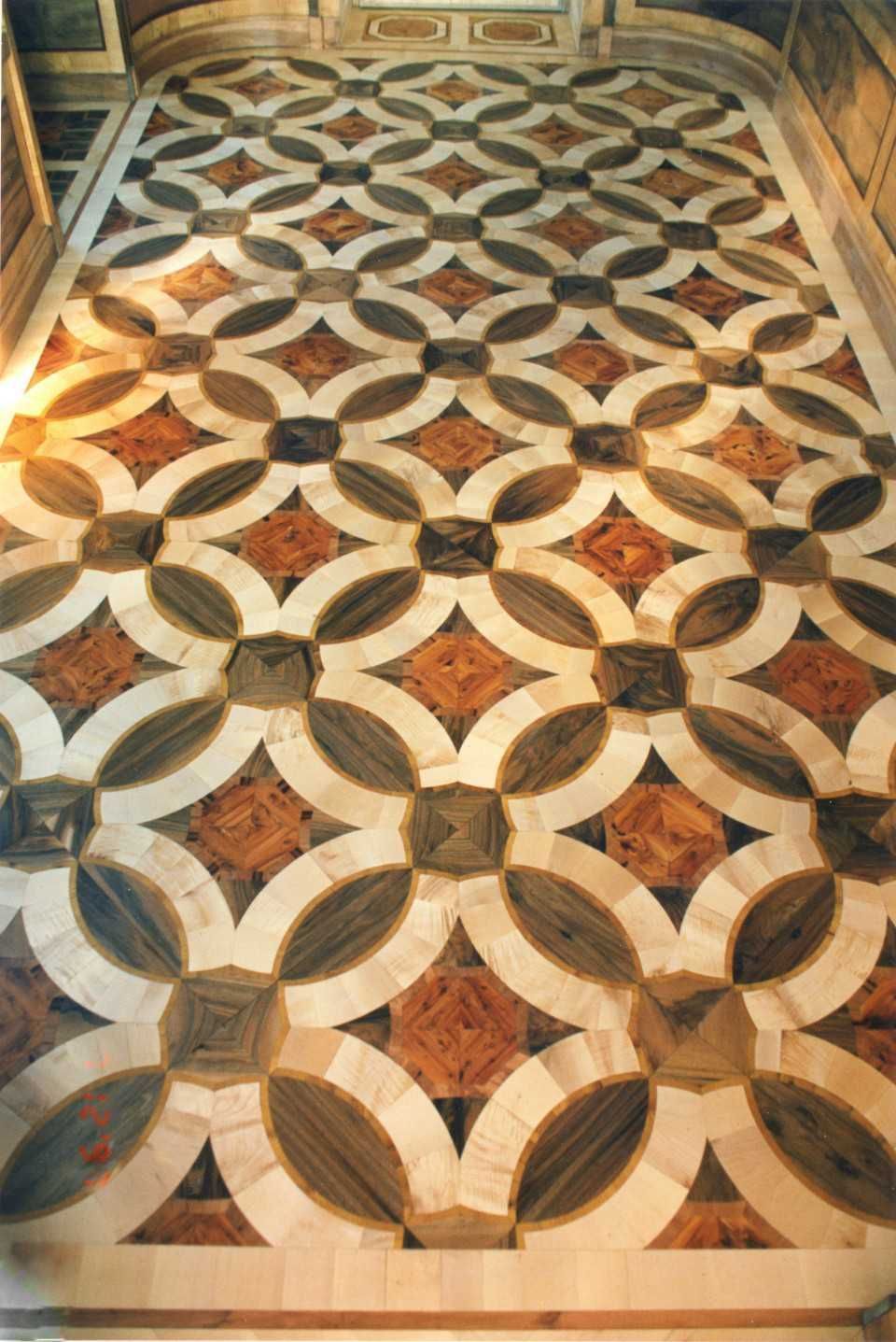 Ornamentierter geometrischer Boden aus Holz und Marmor mit ineinandergreifendem Kreismuster in warmen Farbtönen