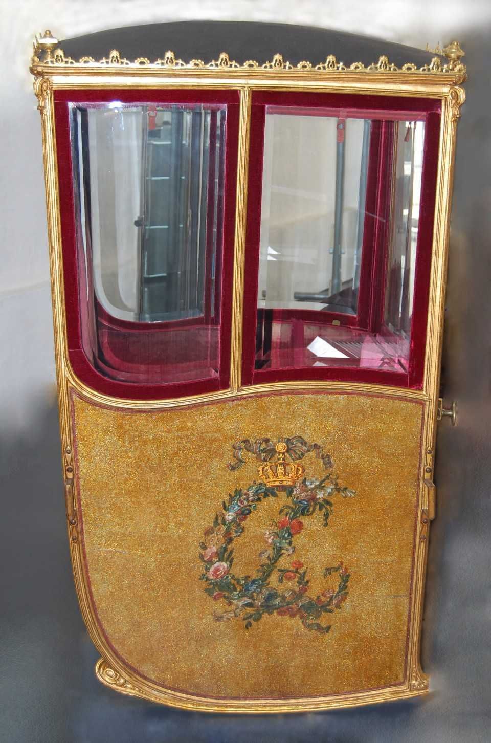 Verschnörkelte Glasvitrine in Rot und Gold mit floralem Monogramm auf der Vorderseite