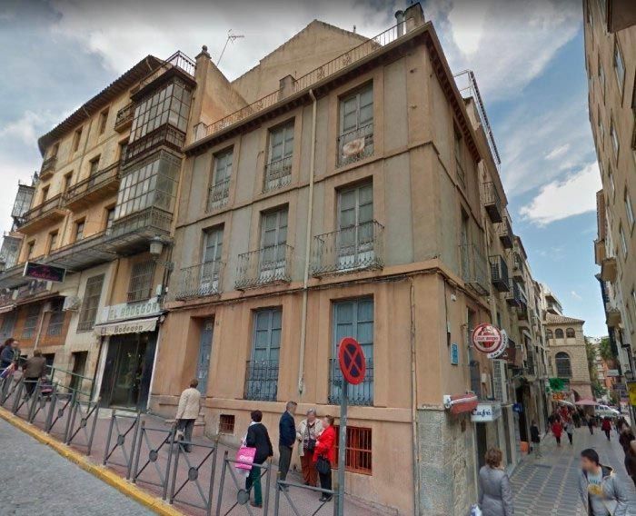 Un edificio con un cartel de prohibido estacionar enfrente.