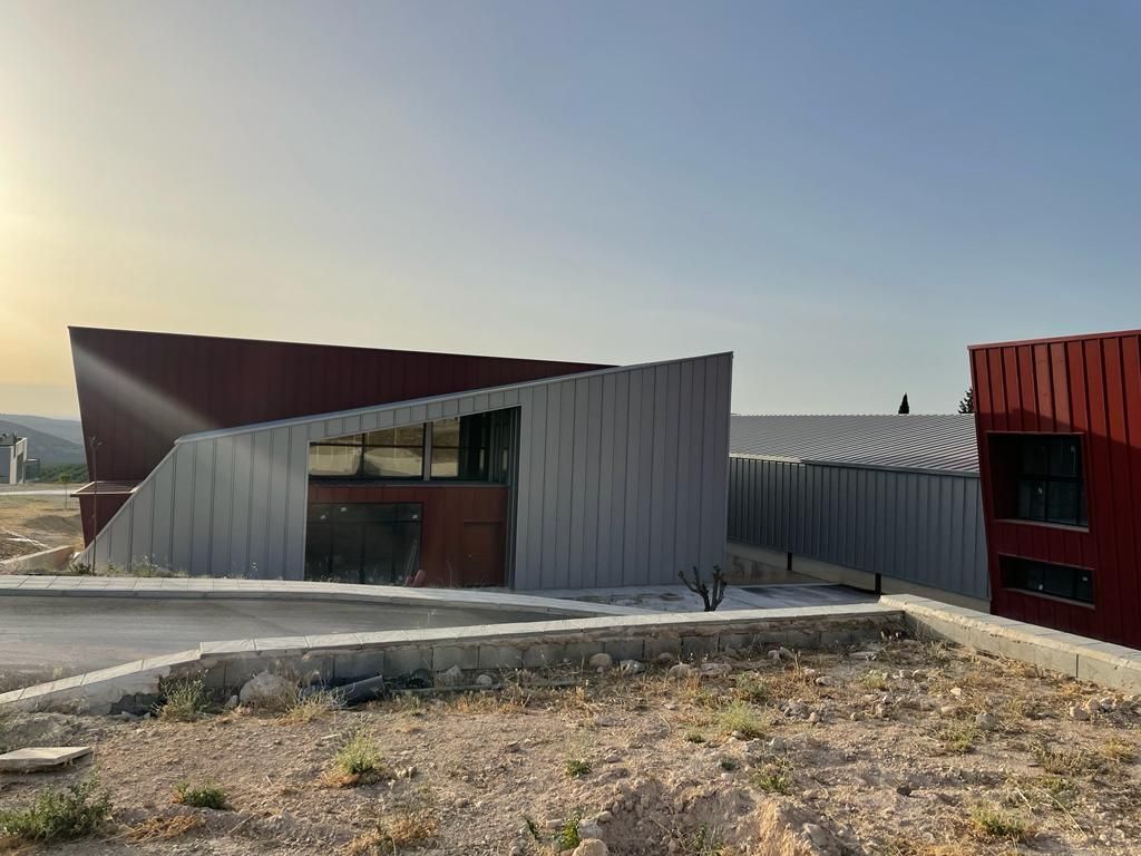 Un gran edificio está situado en la cima de una colina de tierra.