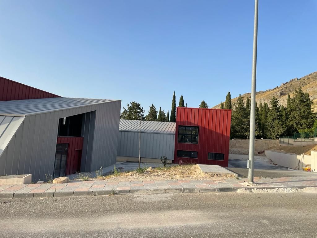 Un edificio rojo y gris con un cielo azul de fondo.
