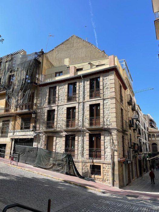 Se está construyendo un edificio con muchas ventanas en una colina.