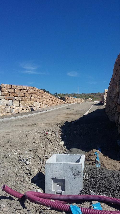 Una caja de hormigón se encuentra en el suelo junto a una carretera.
