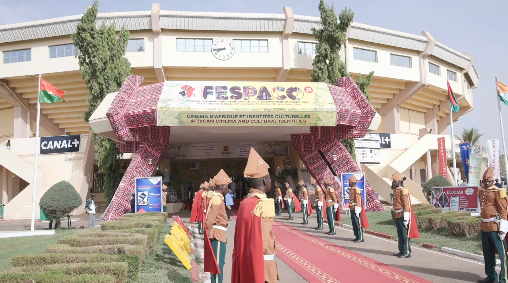 Entrée au festival de cinéma FESPACO avec fanfare en uniforme, tapis rouge et stade.