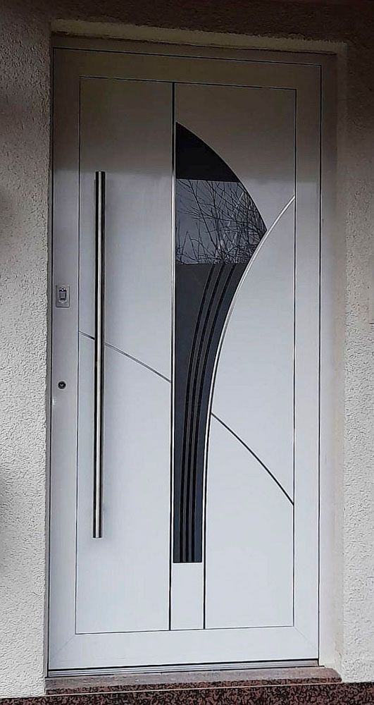 Weiße Haustür mit moderner, gebogener Glasscheibe und langem, vertikalem Türgriff in einem Stuckeingangsbereich
