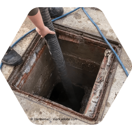 Eine Person pumpt Wasser in einen Kanaldeckel, Rohrreinigung Frank Welbers