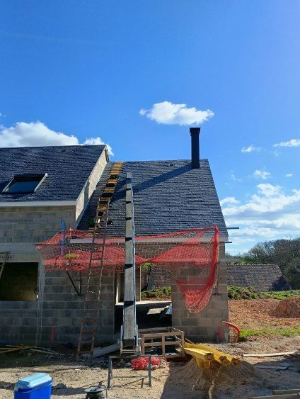 Une maison en construction avec un toit en bardeaux, une cheminée, une échelle de toit et un filet de sécurité.