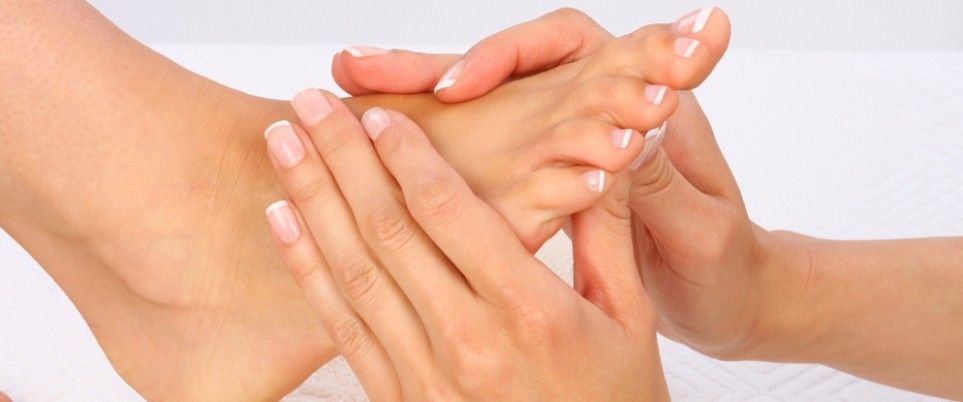 Handen masseren een voet.