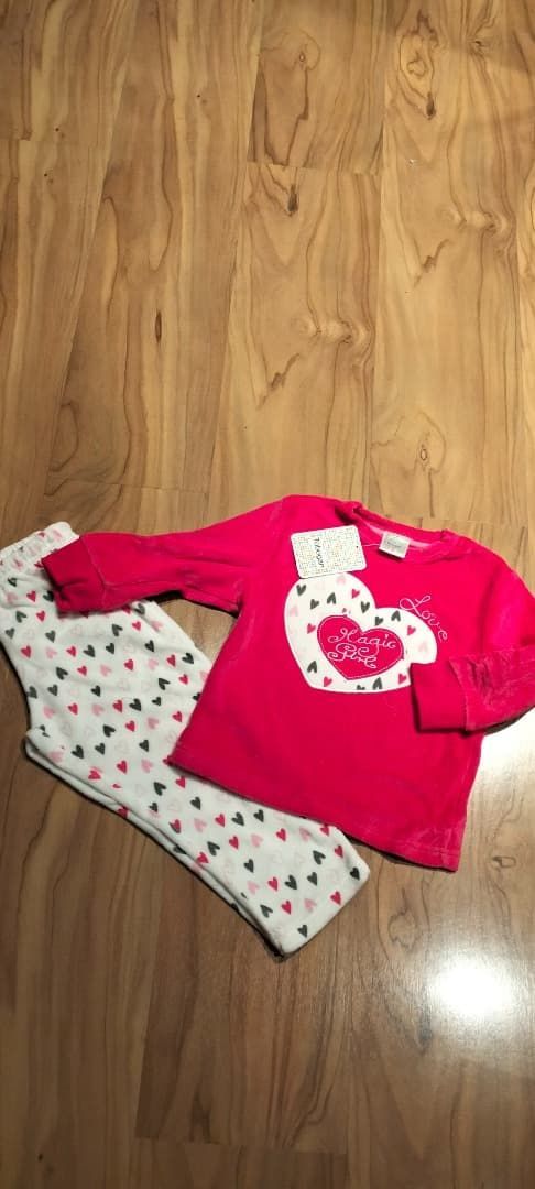 Camisa rosa y leggings blancos con lunares sobre un suelo de madera