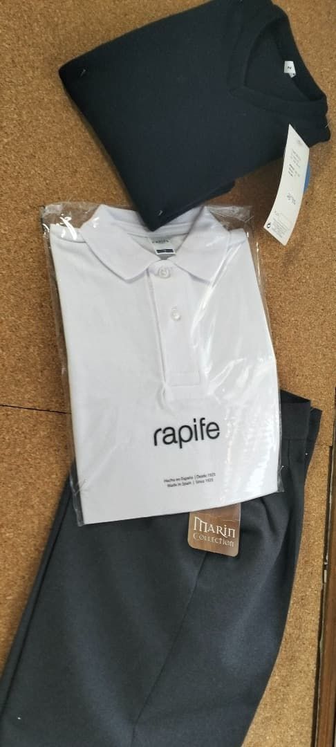 Prenda negra con una etiqueta blanca de Rapha, colocada sobre una superficie de corcho.