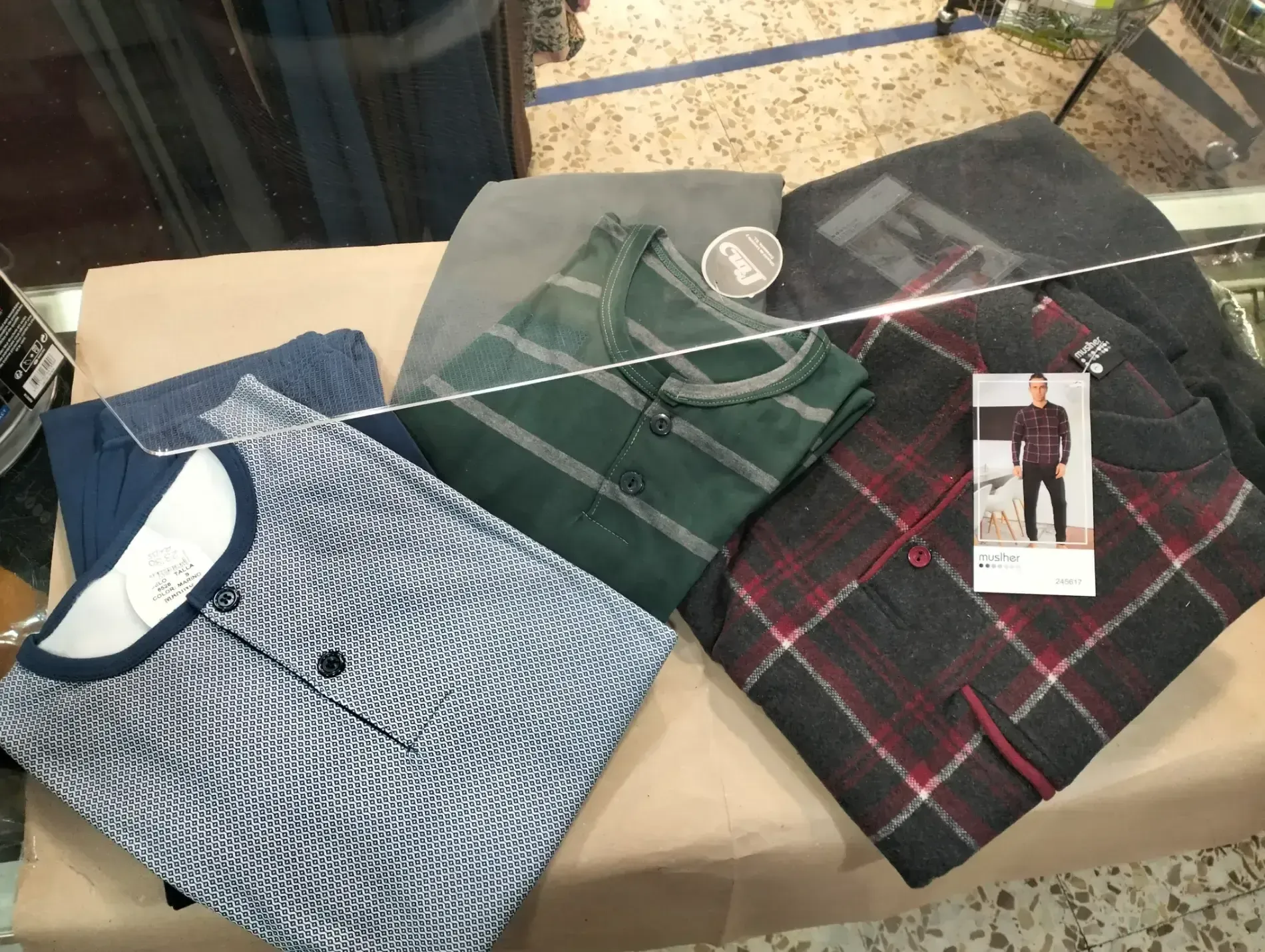 Sobre una mesa se exhiben diversos pijamas de hombre.
