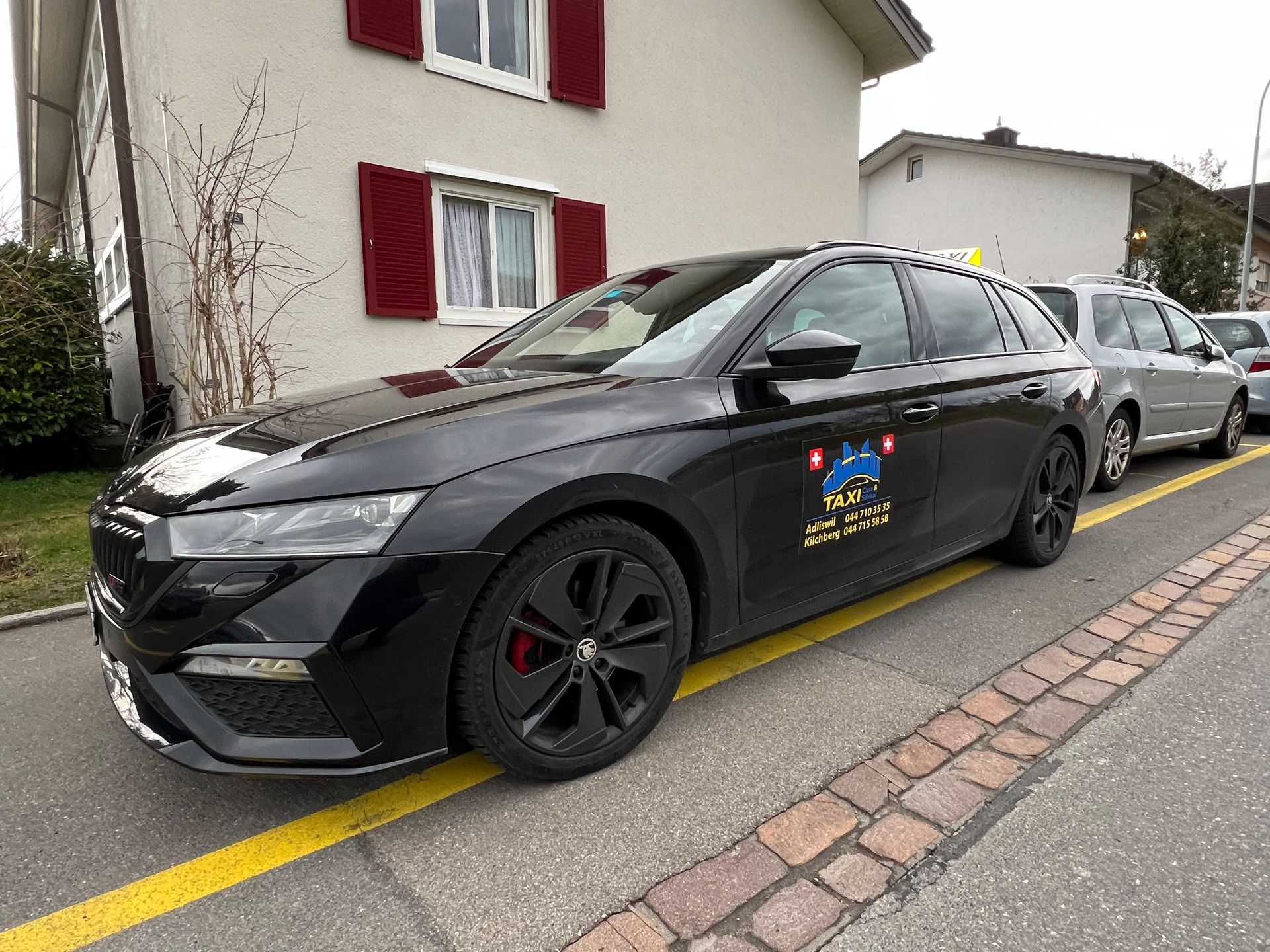 Ein Mann im Rollstuhl wird über eine Rampe in einen Lieferwagen geholfen. Ein zweiter Mann hilft dabei.