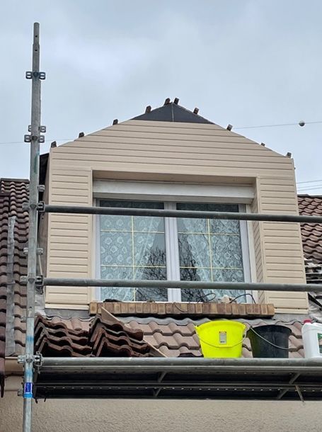 Échafaudages autour d'une fenêtre de toit à battant