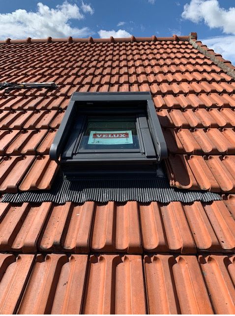 Une fenêtre de toit avec finitions de son étanchéité
