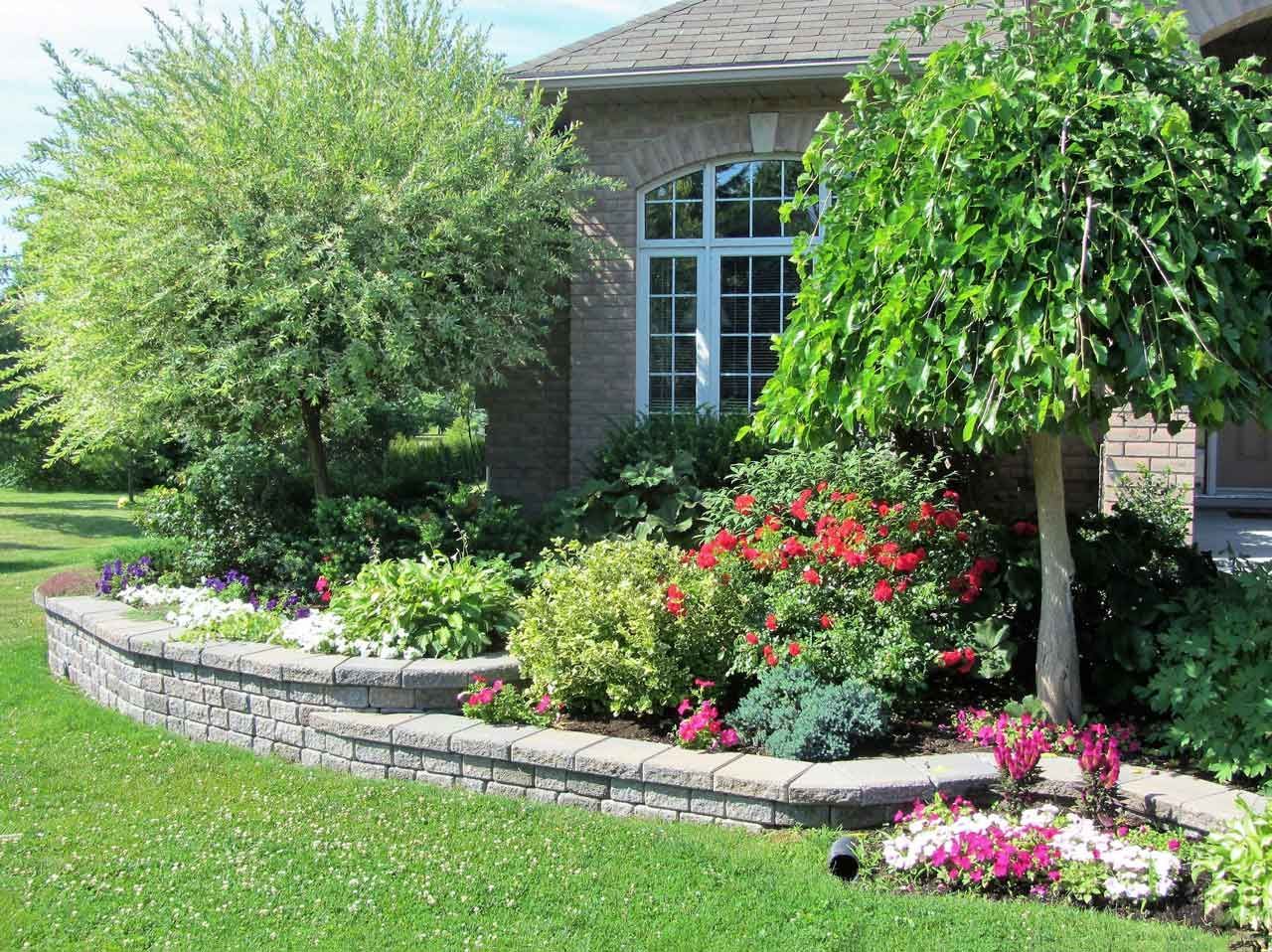 Jardin fleuri et arboré avec murets en pierre