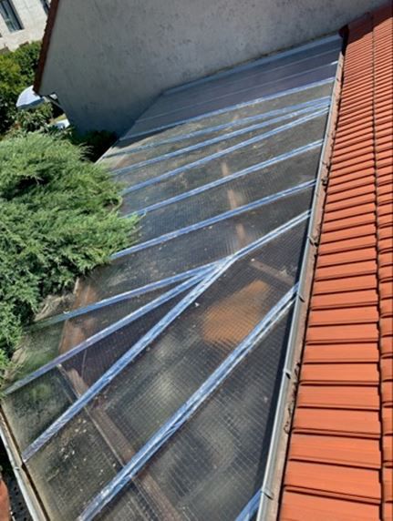 Raccord de zinguerie entre un toit de véranda et une toiture en tuile