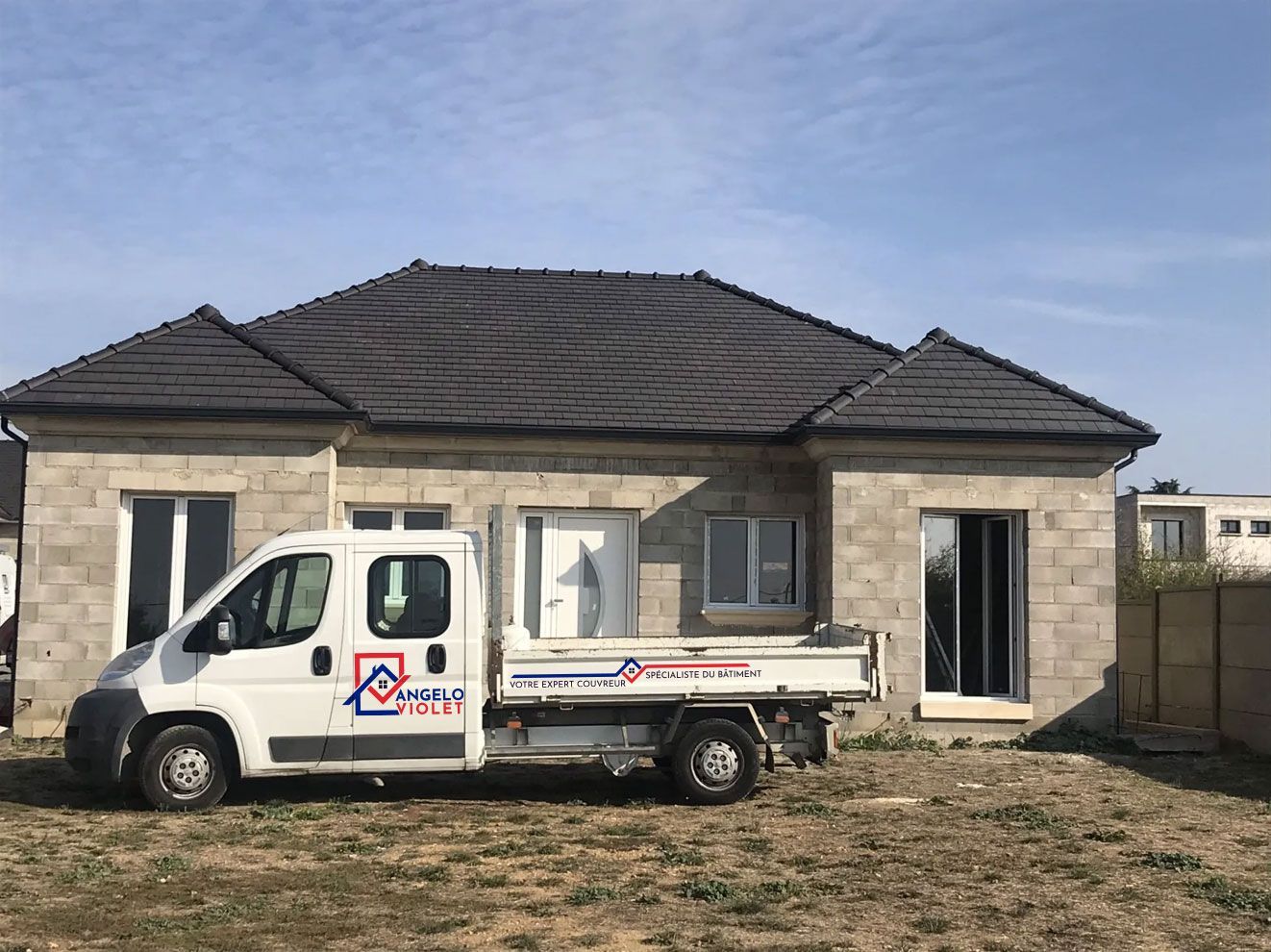 Le camion de l'entreprise Angelo Violet devant une maison en construction