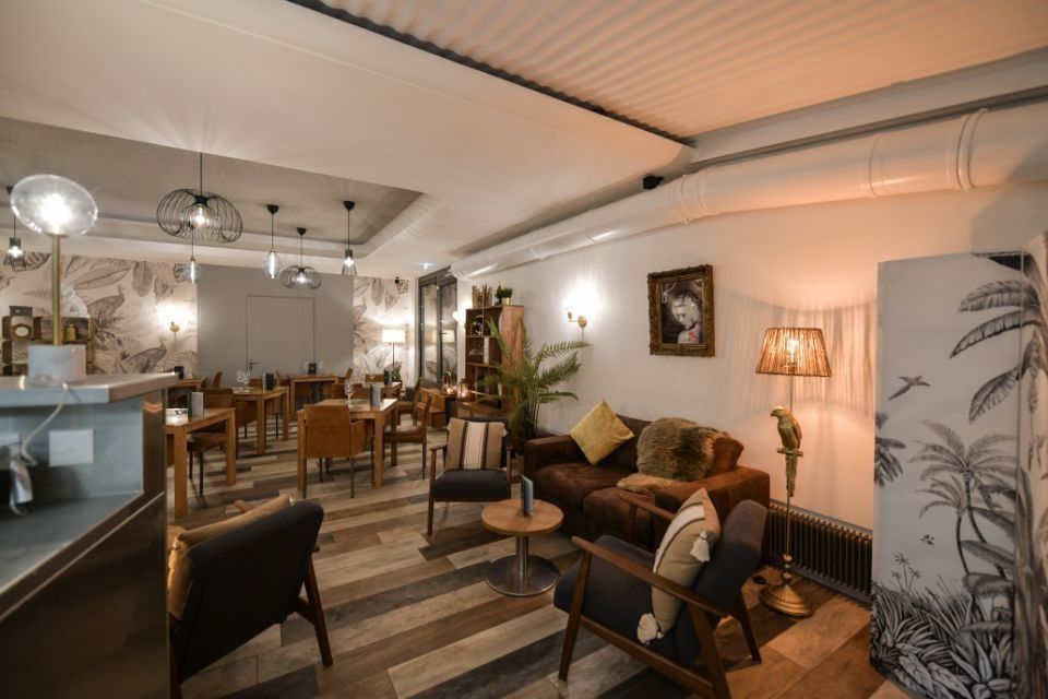 Un salon avec un canapé, des chaises et des tables dans un restaurant.