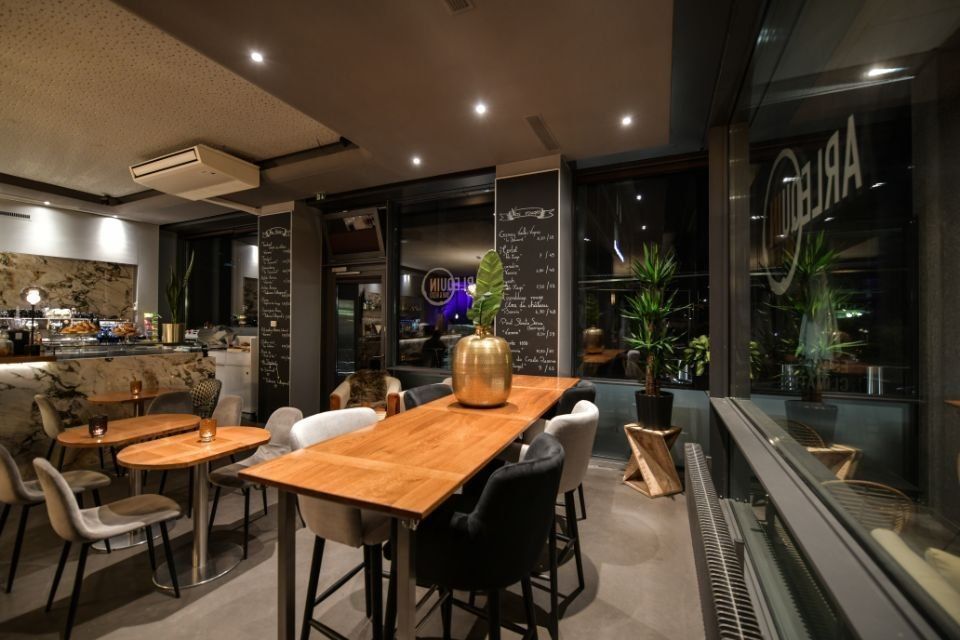 Un restaurant avec des tables et des chaises et une grande fenêtre.