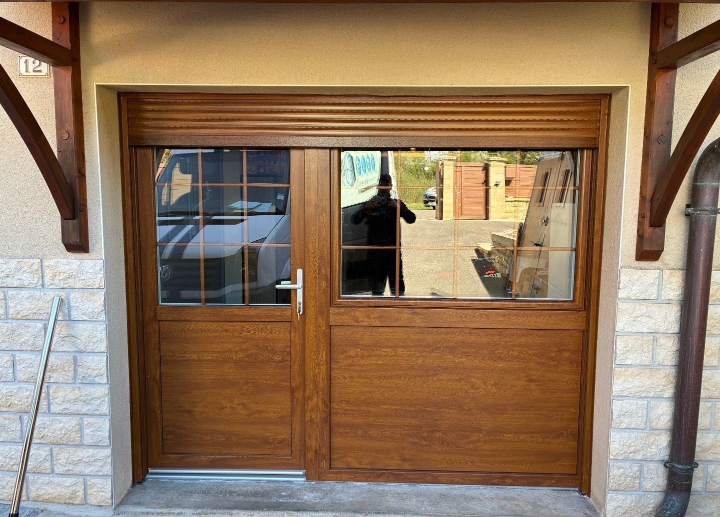 Portes doubles en bois avec des fenêtres vitrées à l’entrée d’un bâtiment en pierre.