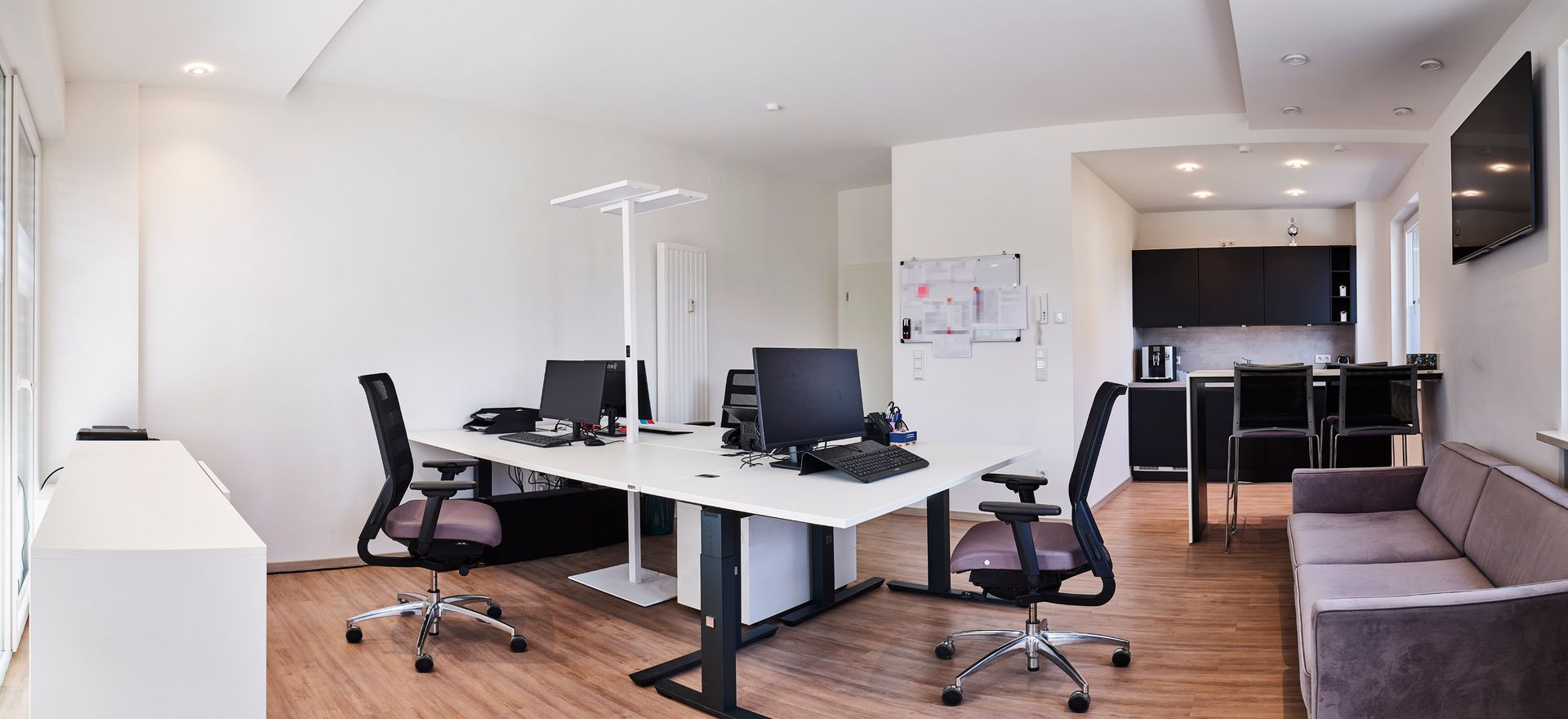 Ein Panoramablick auf ein Büro mit einer Couch und Stühlen