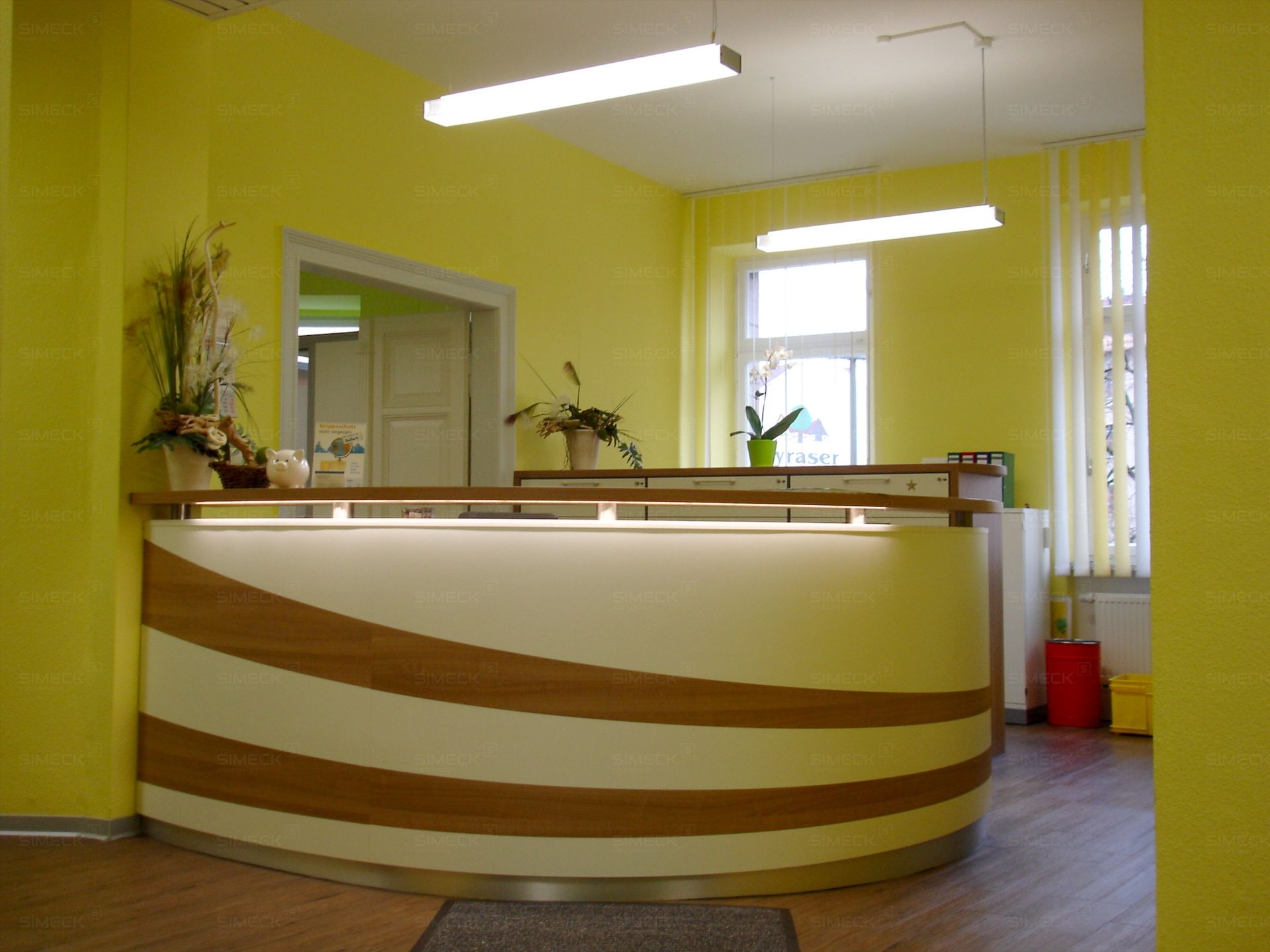 Eine Rezeption in einem Raum mit gelben Wänden