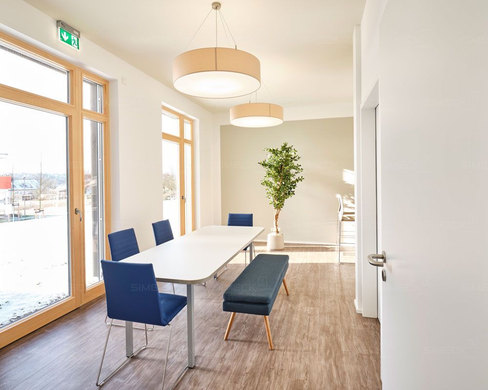 Ein Konferenzraum mit einem Tisch, Stühlen und einer Bank.
