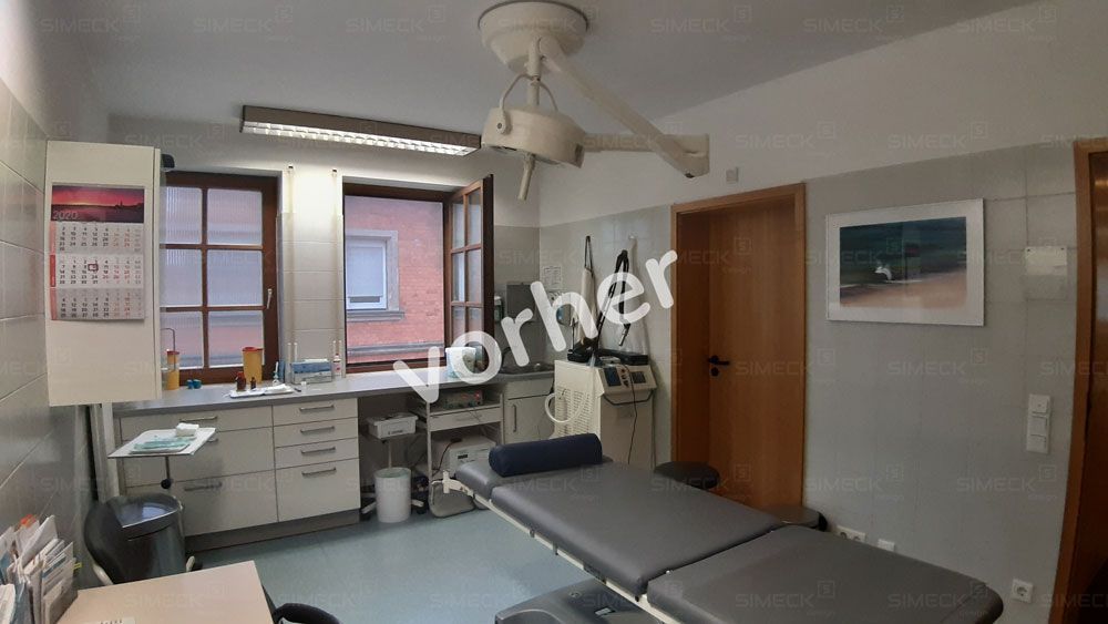 Eine Arztpraxis mit einem Bett und einem Deckenventilator.