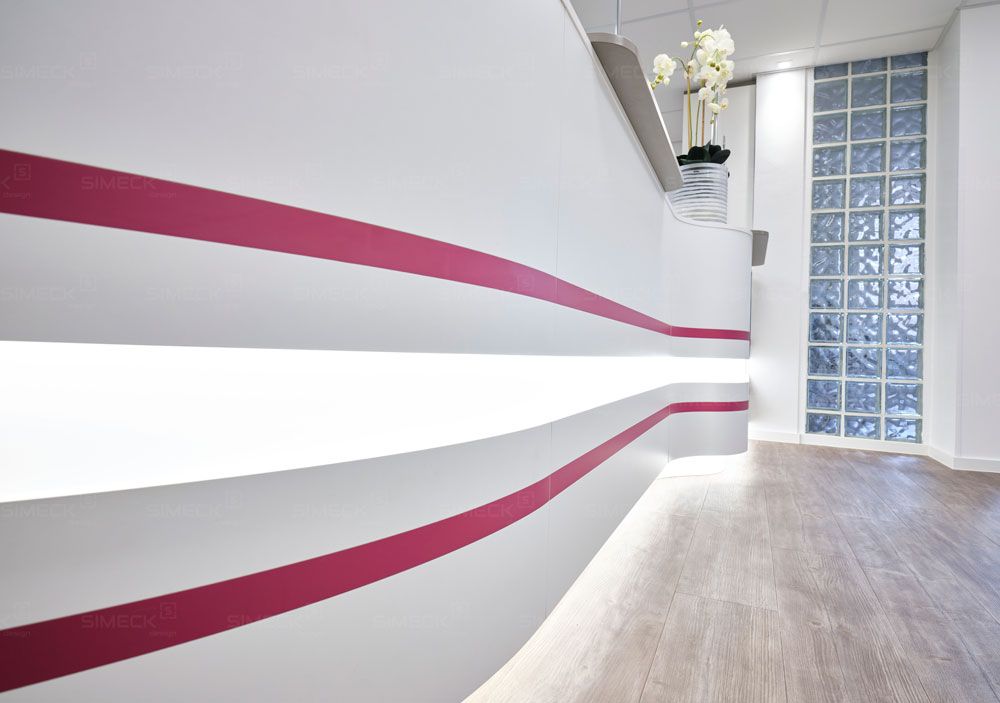 Ein weißer Rezeptionstresen mit einem rosa Streifen an der Seite