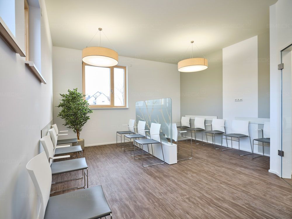 Ein Wartezimmer mit vielen Stühlen und einem Fenster.
