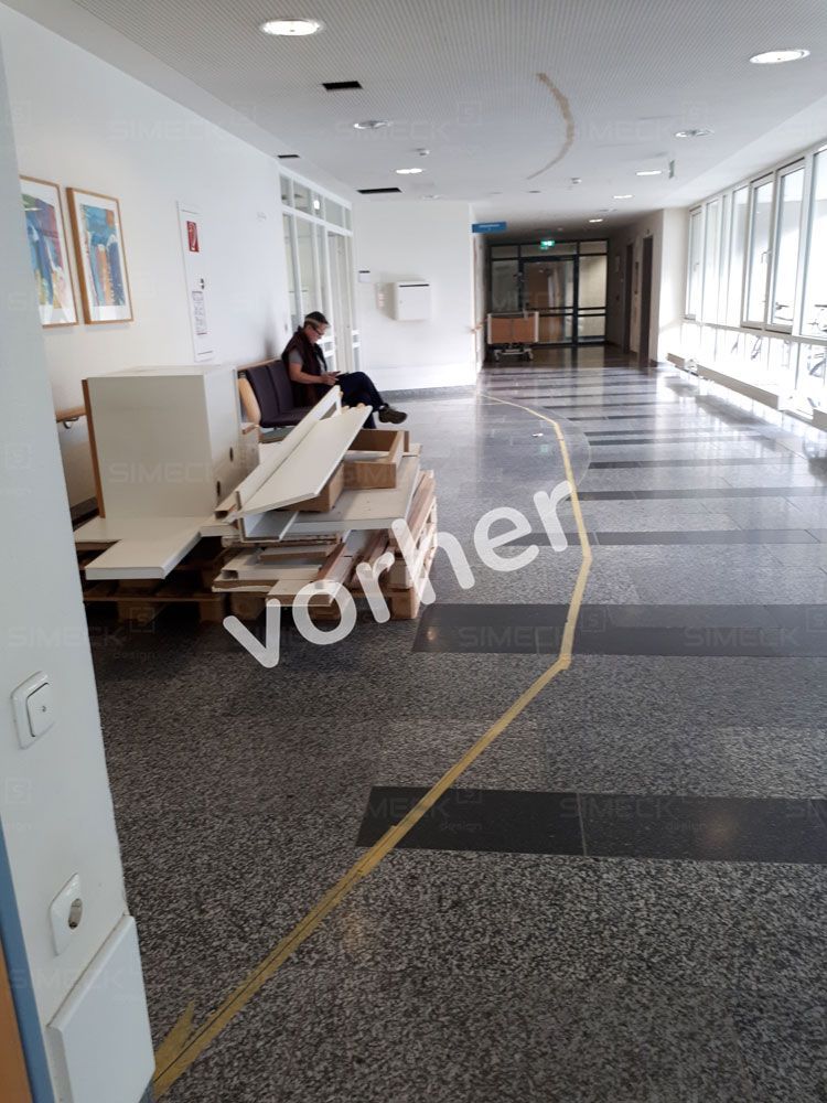 Ein Mann sitzt auf einem Sofa in einem Flur, auf dessen Boden das Wort „Vorher“ steht